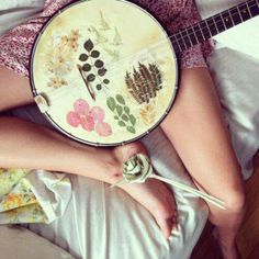 a woman laying in bed with her legs crossed holding a frisbee that has flowers on it