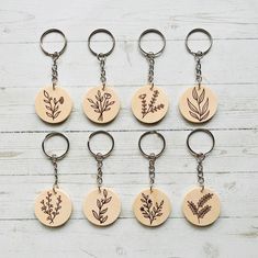 six wooden key chains with different designs on them