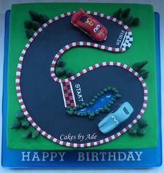 a birthday cake with a race track and cars on it