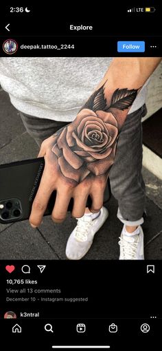 a man with a rose tattoo on his hand and the other hand is holding an iphone