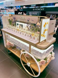 a display in a store filled with lots of bottles and flowers next to a steering wheel