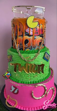 a three tiered cake with glasses on top and decorations around the edges, all in bright colors