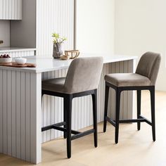 two bar stools sitting in front of a kitchen counter