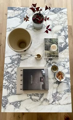 a marble table topped with books and bowls