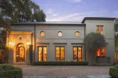 a large white house with lots of windows and lights on it's front door