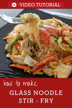 a black plate topped with rice and vegetables next to a fork on top of it