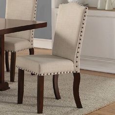 a dining room table with two chairs and a rug