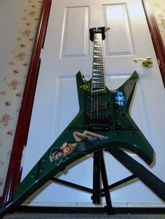 a green guitar sitting on top of a stand