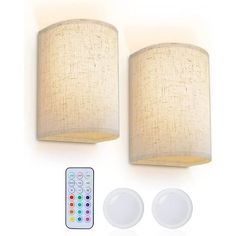 two lights and remote control on a white wall with the same light color as it appears in this image