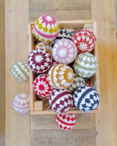 several knitted balls in a wooden box