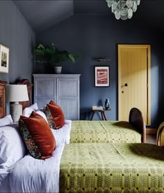 a bedroom with blue walls and green bedding