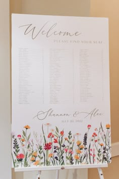 a sign with flowers on it that says, welcome to the guests at this wedding