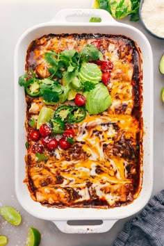 an enchilada dish with tomatoes, avocado and other ingredients in it