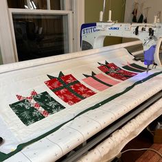 a sewing machine sitting on top of a table next to a christmas tree quilting block