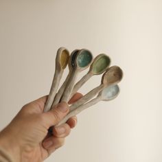 a person holding five spoons in their hand