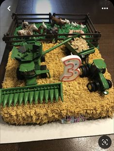 a birthday cake made to look like a farm scene with tractors and animals on the field