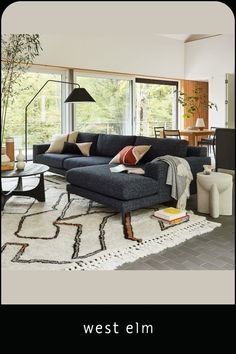 a living room filled with furniture and a large window covered in lots of natural light