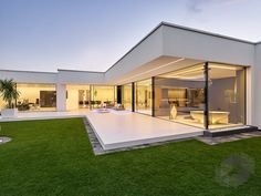 a modern house with an open patio and lawn