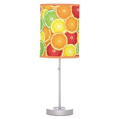 a table lamp with an orange and lime pattern on it's fabric shade is shown