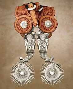 two pairs of silver and brown leather cowboy boots with sunbursts on them