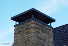 a brick chimney on top of a building with a blue sky in the back ground