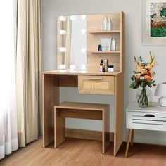 a wooden desk with a mirror on top of it and flowers in the vase next to it