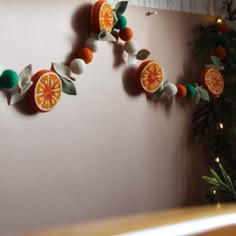 an orange decoration hanging on the wall next to a christmas tree