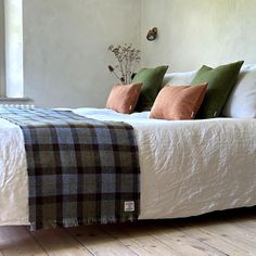 a bed with plaid blankets and pillows on it