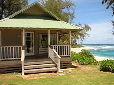 a house on the beach with steps leading up to it's front door and porch