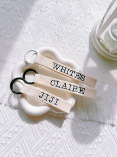 two pairs of scissors sitting on top of a white table cloth with words written on them