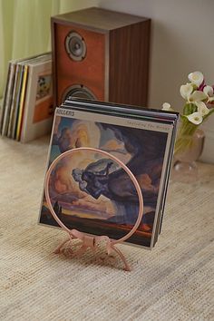 there is a cd case with a painting on it and some books in the background