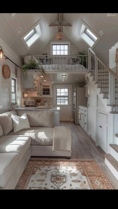 a living room filled with furniture next to a stair case in a loft style home