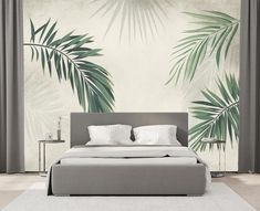 a bed sitting in front of a wall with palm leaves on it's side