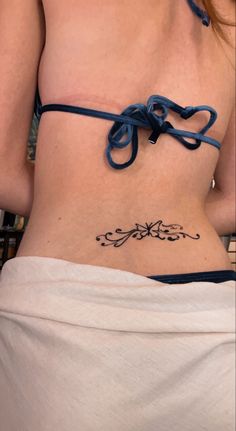 a woman with a tattoo on her stomach wearing a blue string around her waist and under her belly