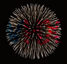 fireworks are lit up in the dark sky with red, white and blue lights on them