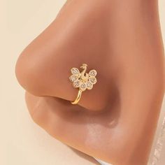 a close up view of the side of a nose with a flower and diamond ring on it