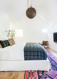 a bed room with a neatly made bed and a rug