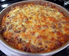 a casserole dish with cheese and meat in it on top of the stove