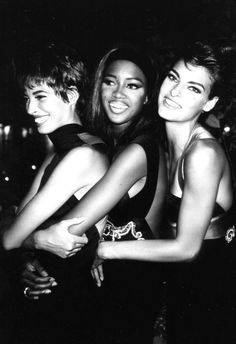 three young women are posing together in black and white, with their arms around each other