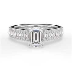 an emerald cut engagement ring with baguetts on the band and side stones in white gold