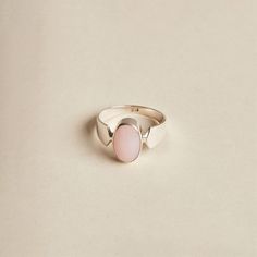 The Pink Opal is a lovely stone to wear. Its soft, baby pink oval cabochon is highlighted by the band's design. The ring is made with 925 sterling silver. The ring is available in size 6 3/4, 7.5, 9, 9.5. Dimensions: Total height: 15mm Total width: 11mm Stone height: 14mm Stone width: 10mm Stone + bezel thickness: 7mm Band width: 8mm to 3mm - Please note - * Additional photos and videos available on request * Go to 'About us' section for links to our socials and website * Only the ring from firs Classic Pink Ring With Polished Finish, Adjustable Oval Cabochon Moonstone Ring, Adjustable Pink Round Opal Ring, Adjustable Pink Opal Ring, Elegant Pink Opal Sterling Silver Ring, Adjustable Oval Opal Ring Minimalist Style, Classic Adjustable Jewelry With Oval Cabochon, Elegant Pink Opal Ring In Sterling Silver, Adjustable Classic Jewelry With Oval Cabochon