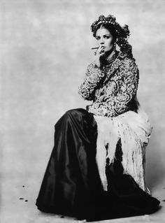 an old black and white photo of a woman sitting in front of snowflakes