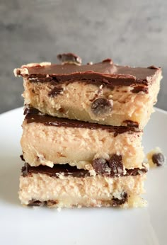 three pieces of chocolate chip cookie bars stacked on top of each other in front of a gray background