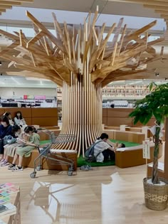 people are sitting on couches in a library with wooden beams hanging from the ceiling