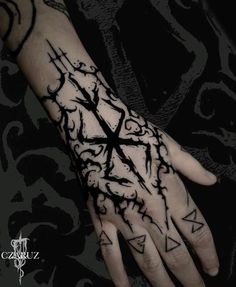 a person's hand with tattoos on it and an ink pen in the middle