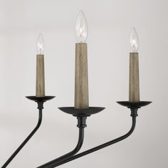 three light chandelier with two candles on each candle holder and one is black