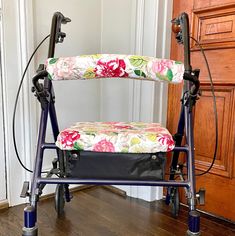 a blue walker with flowers on it sitting in front of a door and wooden floor