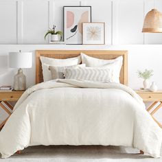 a bed with white sheets and pillows in a room