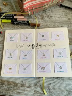 an open notebook with the words best moments written on it next to markers and pencils