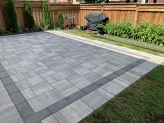 an empty backyard with a large stone patio